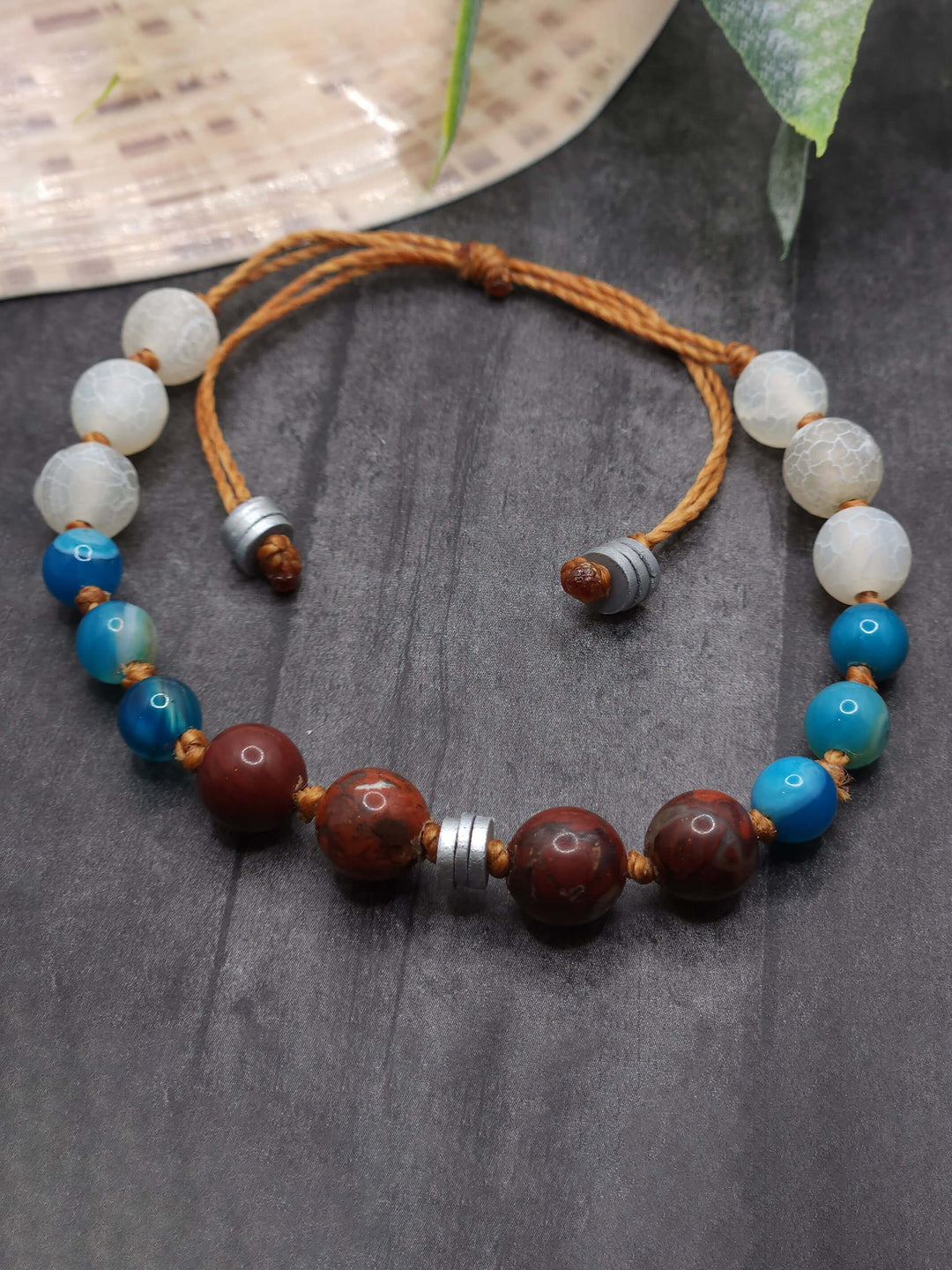 This picture of the Crashing Waves Bracelet captures the blues, whites, and reds of Bigola Beach in Australia. There are touches of silver throughout.
