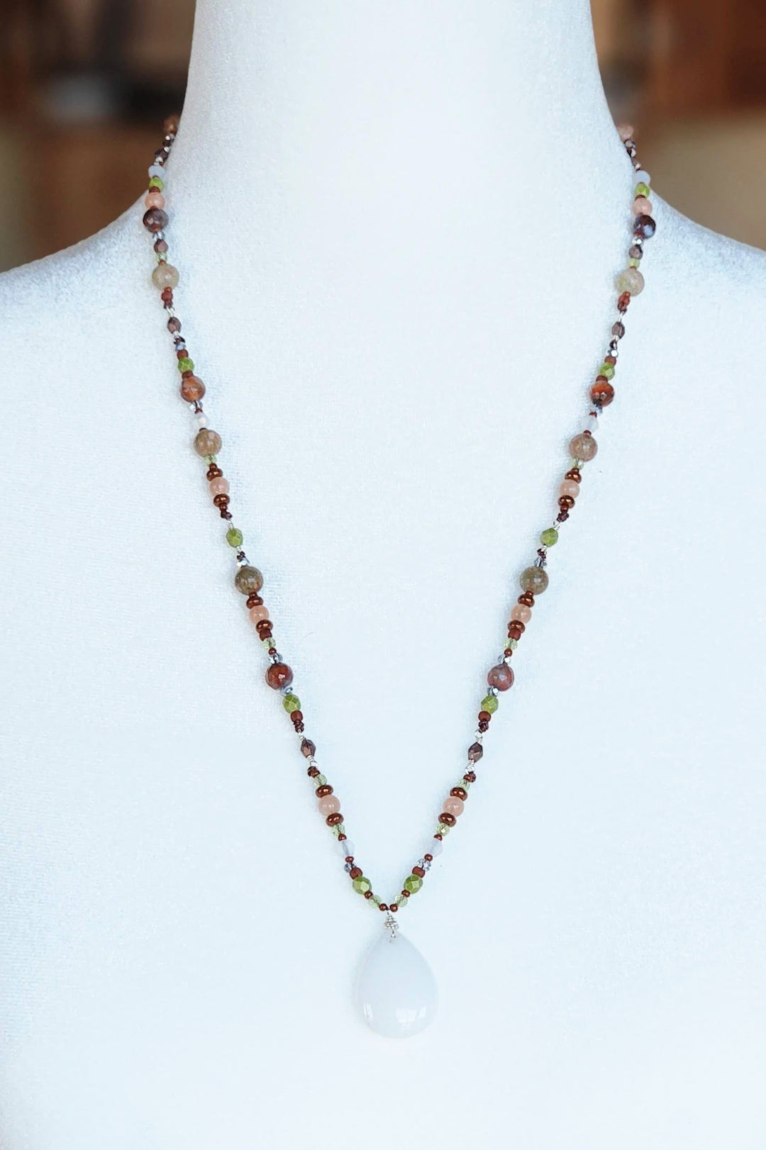 This is a photo displaying Stare of the Mountain Lion Necklace on a white mannequin bust.