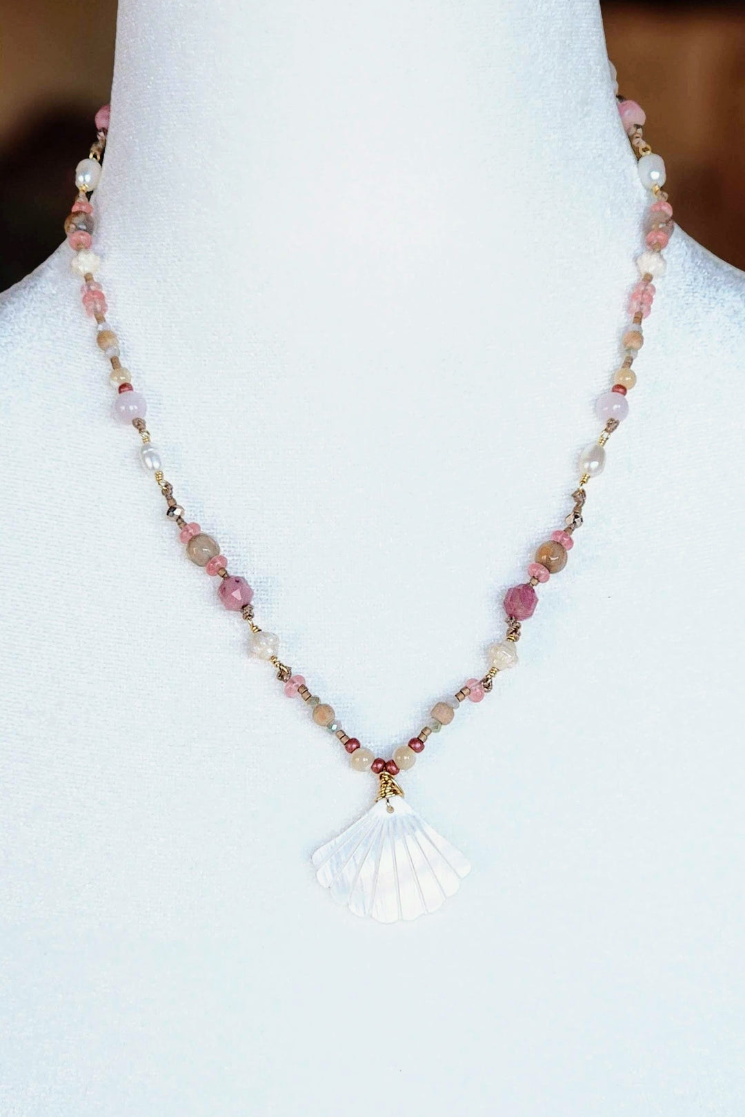 This is a photo displaying the Seashell Necklace on a white mannequin bust.