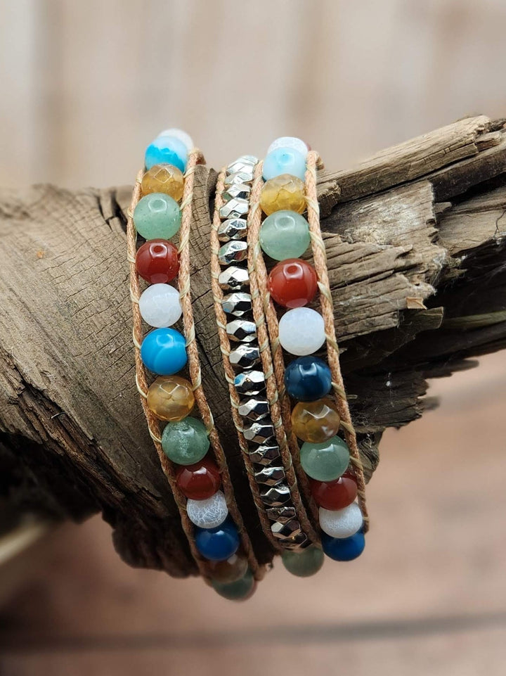 This photo of the 3 wrap butterfly bracelet showcases the blue, yellow, white, orange. green, and silver color pallet of the bracelet.  