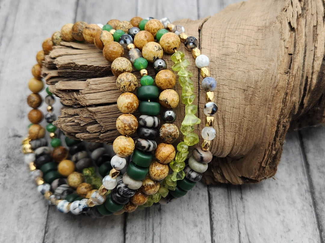 This close-up photo of the Iceland Mountain Stream Memory Wire Bracelet captures the color pallet of greens, browns, and grays of the bracelet with gold spacers.