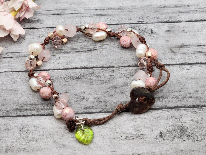 This is a beautiful cluster style bracelet that captures the pink, white, and brown of Cherry Blossoms on a branch.   